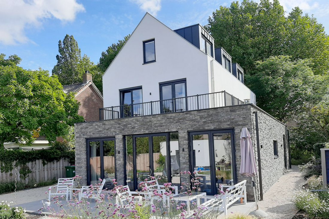Balkonhekwerk bij een woning met houtaccenten in de gevel