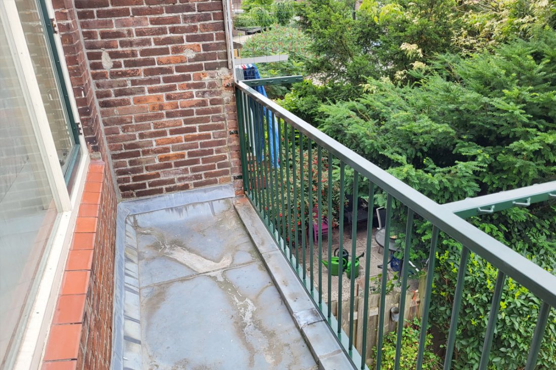 Antracietgrijs balkonhekwerk langs een balkon met uitzicht op de straat