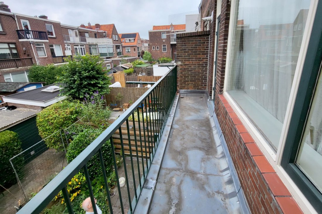 Balkonhekwerk in een donkere kleur dat wegvalt tegen de gevel