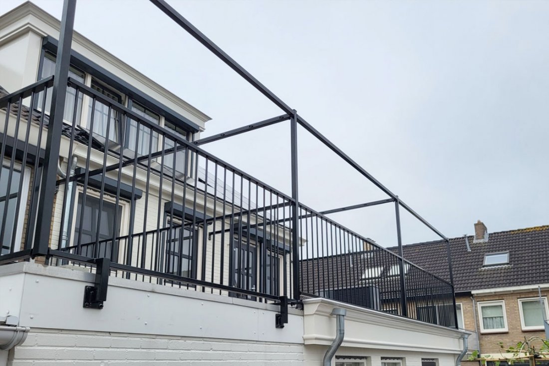 Balkonhekwerk langs een terras met kunstgras, strak op maat aangesloten