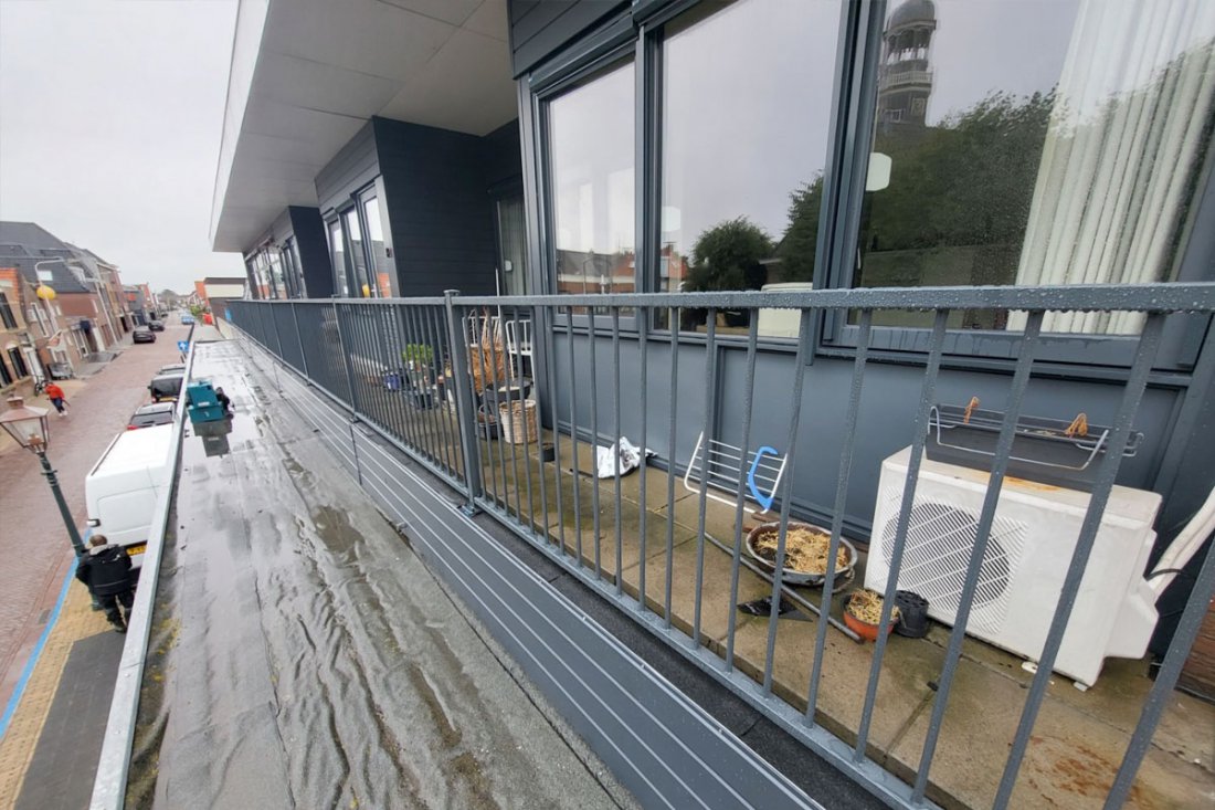 Balkonhekwerk aan de gevel van een appartementencomplex met meerdere identieke balkons