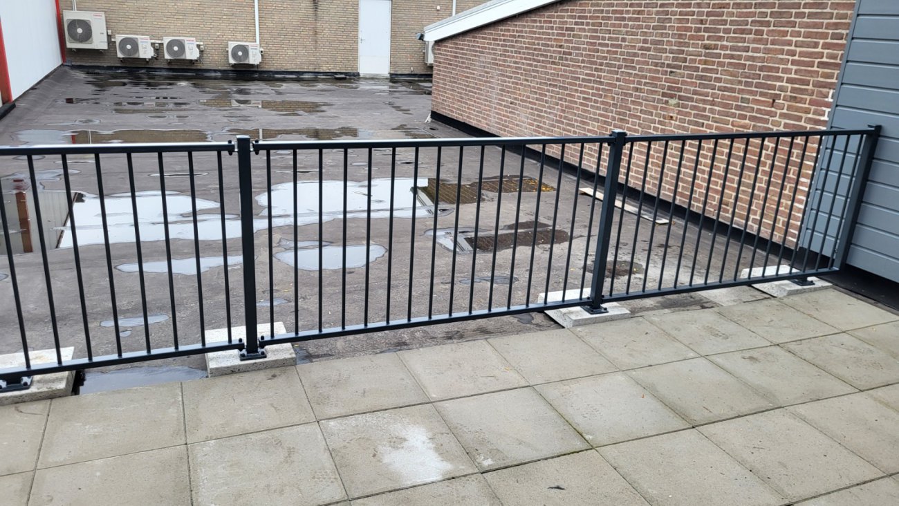 Balkonhekwerk rondom een dakterras, vastgezet op de betonnen dakrand