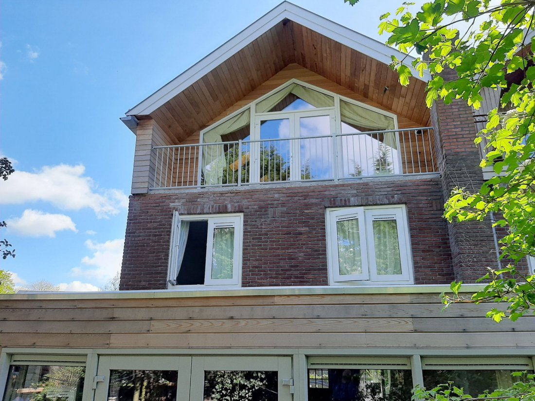 Dakterras op de bovenverdieping van een woning met hekwerk langs de rand