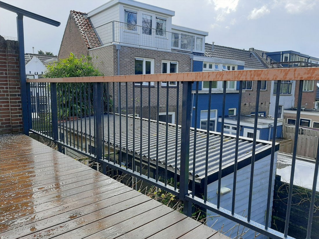 Hekwerk op een houten vlonder van een dakterras met een brede bovenregel