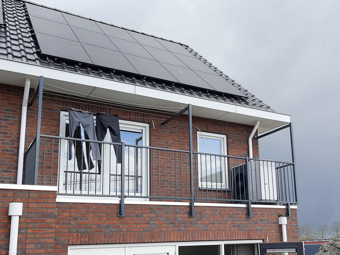 Hekwerk langs de dakrand van een dakterras bij een woning met zonnepanelen