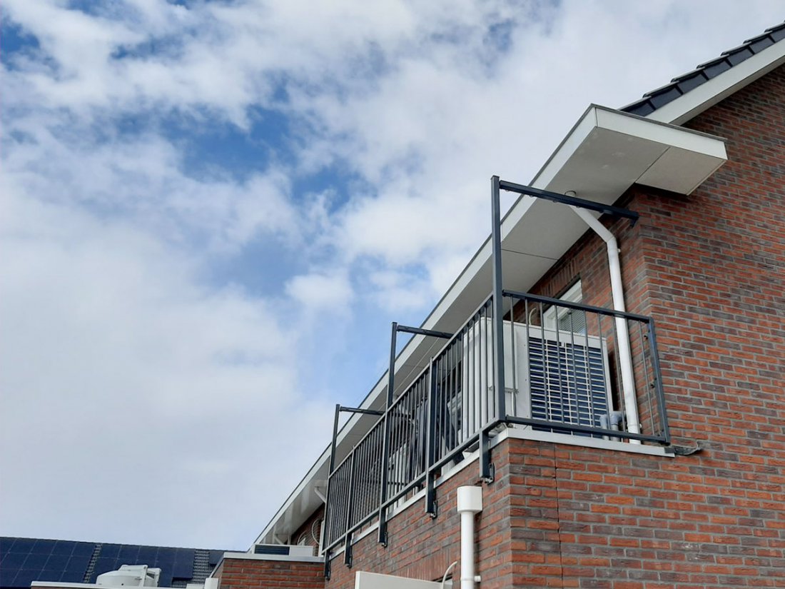 Detail van een dakrand met hekwerk erboven bij een dakterras