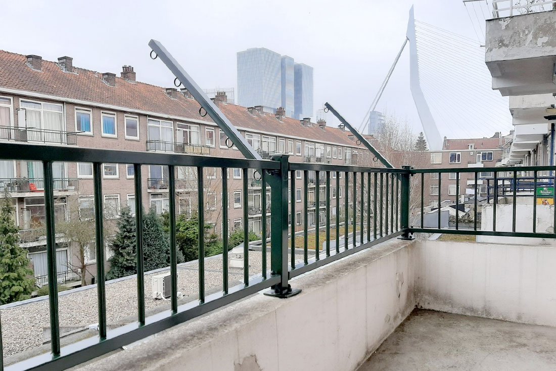Open spijlenhek op een dakterras met vrij uitzicht over de stad