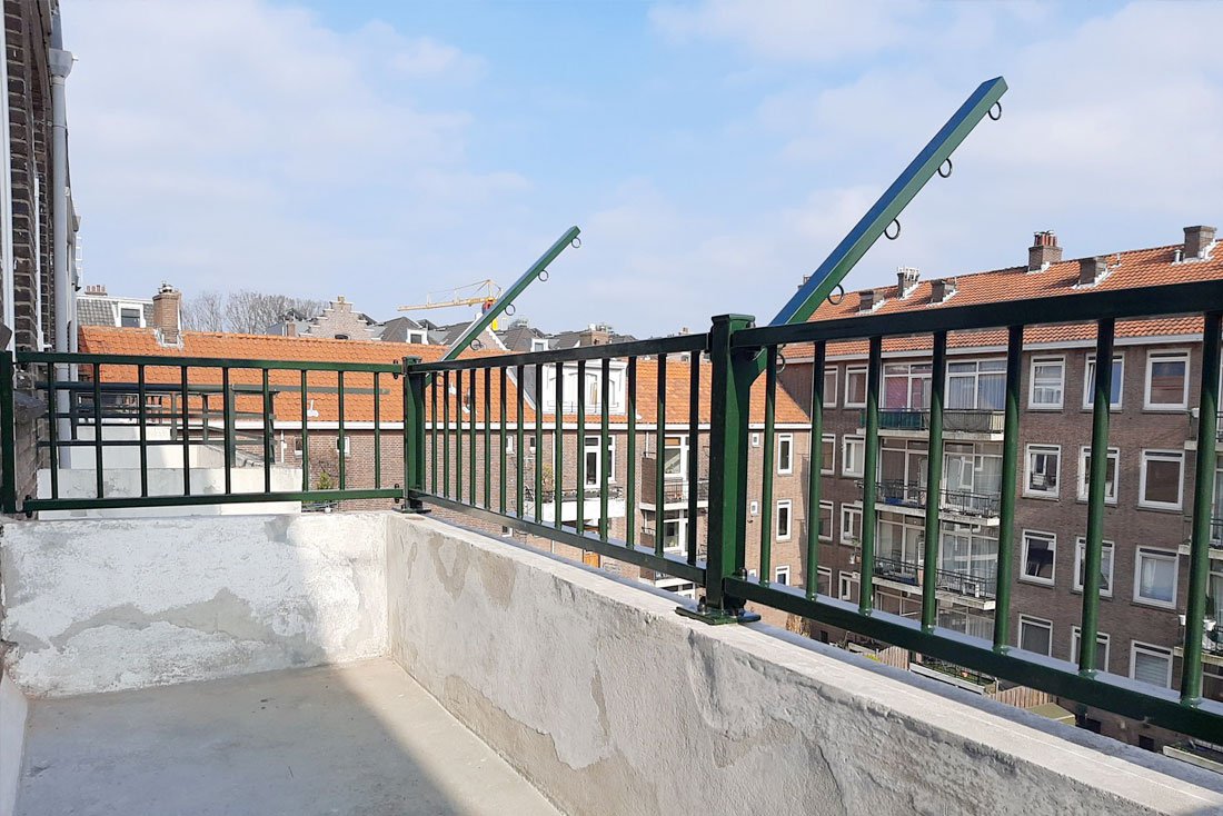Hekwerk langs een dakterras met uitzicht op de skyline