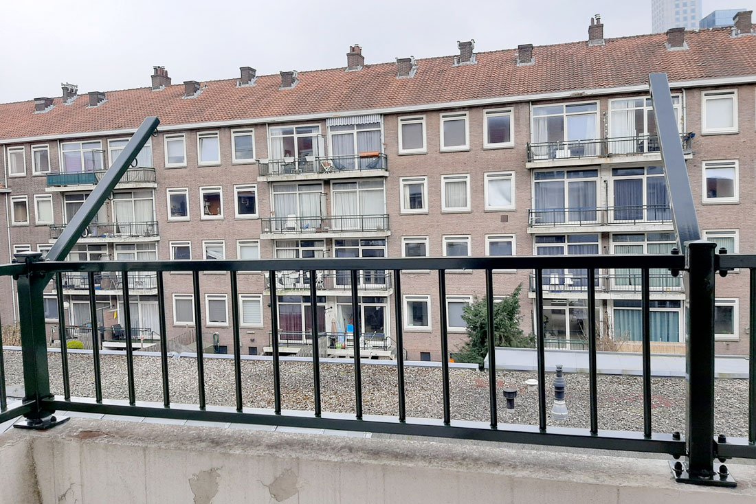 Hekwerk rond een dakterras met uitzicht over de wijk