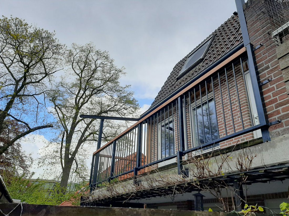 Hekwerk op een dakterras hoog aan de gevel van een woning