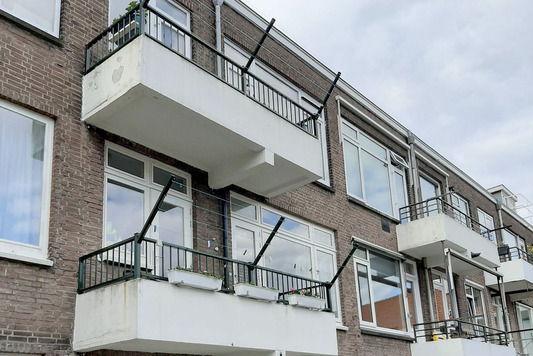 Dakterrassen met hekwerk aan de achterzijde van een appartementencomplex
