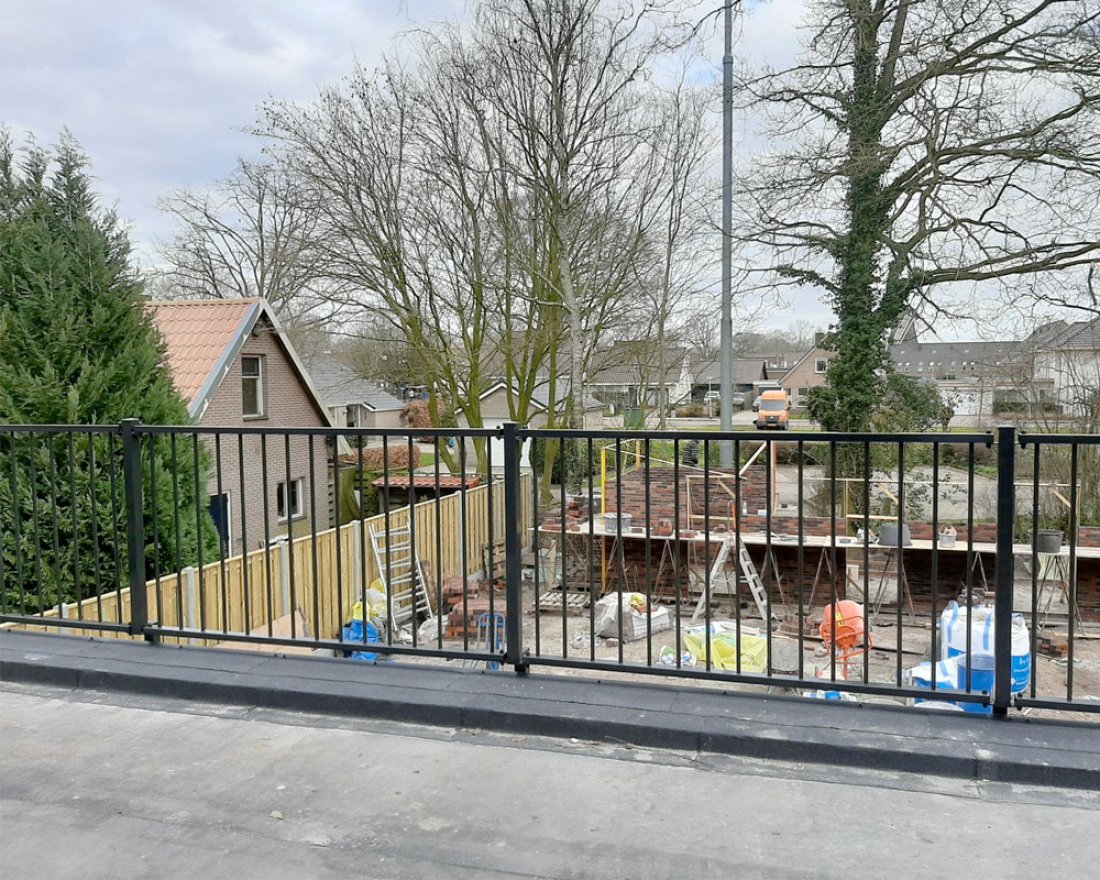 Hekwerk rond een dakterras met uitzicht op de omliggende woningen