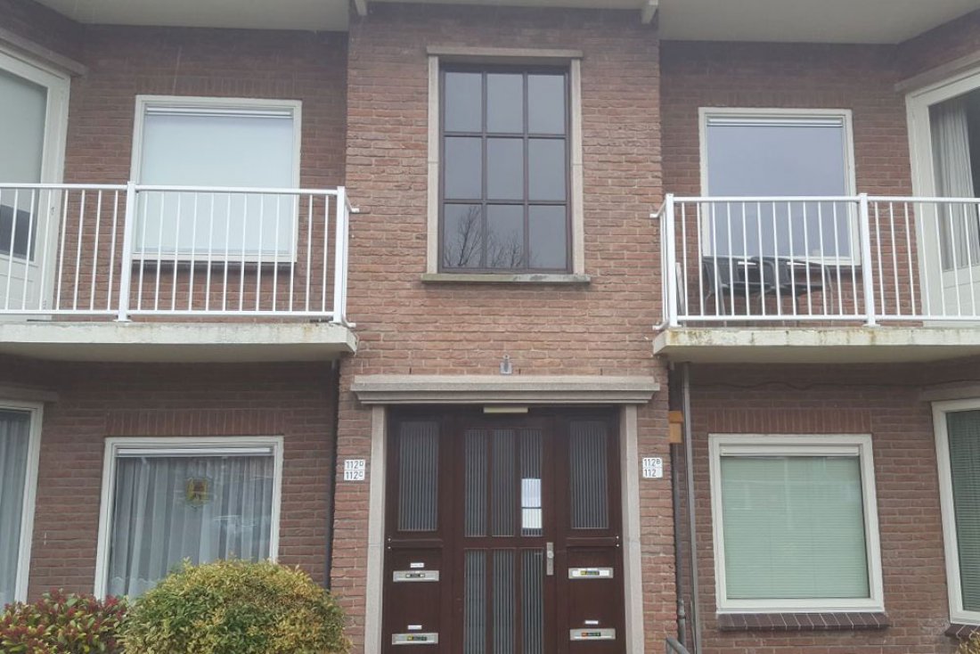 Hekwerk langs de gevel van een gebouw met meerdere balkons