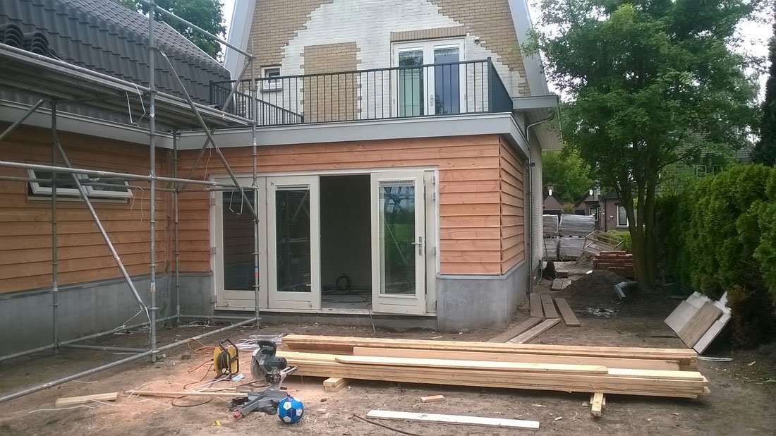 Hekwerk langs een balkon tijdens werkzaamheden aan een woning