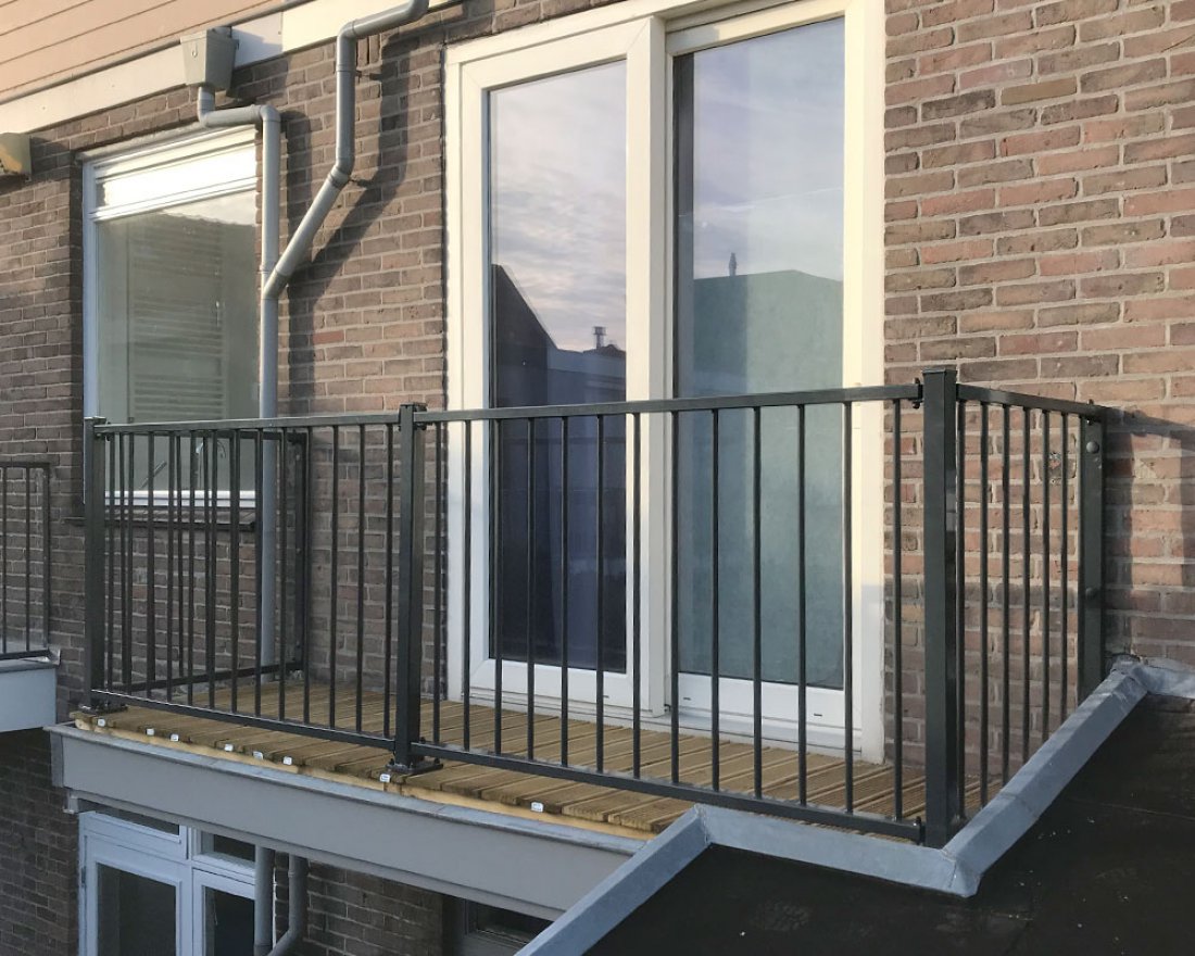 Hekwerk met glas langs een balkon van een woning