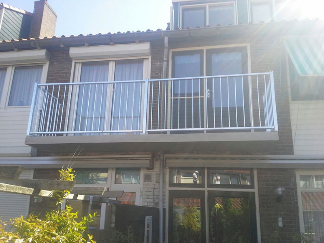 Hekwerk in gelijke secties langs een rij balkons