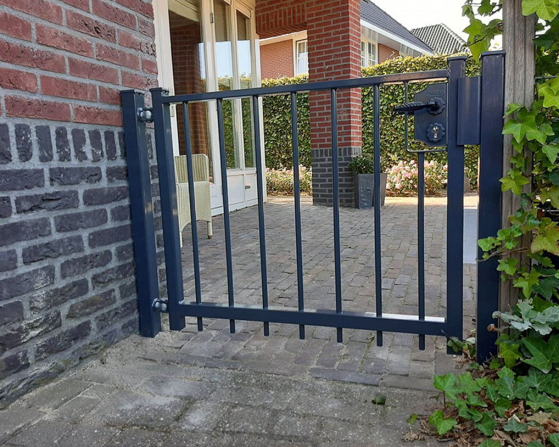 Dubbele tuinpoort in het hekwerk naast een woning